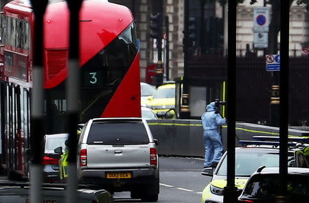 A forensics investigator works at the scene after a car crashed outside the Houses of Parliament in Westminster, London (Reuters)