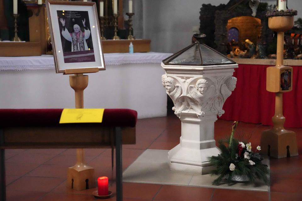 A picture of Pope emeritus Benedict XVI is placed besides a baptistery in the St. Oswald church in Marktl, Germany, Thursday, Dec. 29, 2022. The health of Pope Emeritus Benedict XVI has worsened due to his age, and doctors are constantly monitoring the 95-year-old's condition, the Vatican said Wednesday.(AP Photo/Matthias Schrader)