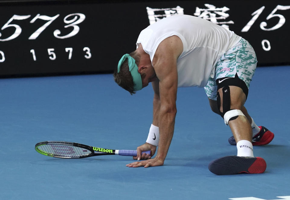 Tennys Sandgren of the U.S. slips on the court during his quarterfinal against Switzerland's Roger Federer at the Australian Open tennis championship in Melbourne, Australia, Tuesday, Jan. 28, 2020. (AP Photo/Lee Jin-man)