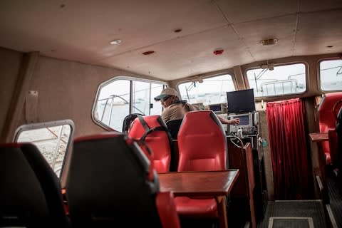 Tourist boat owner Johnny Herne sails out of Jamestown's harbour. It is hoped the new airport could boost visitor numbers - Credit: AFP