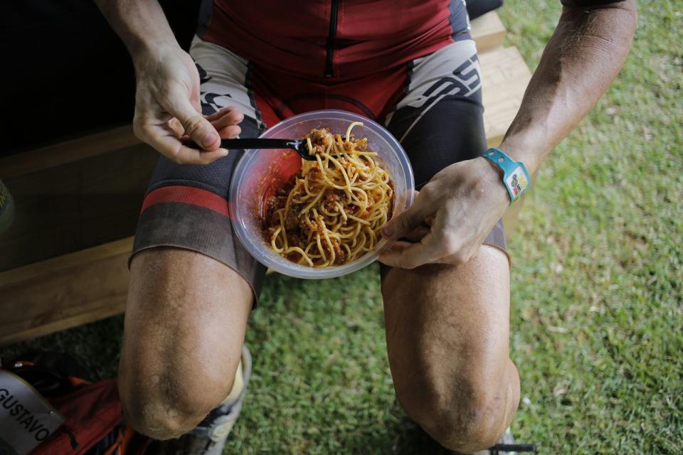 <p>Ein Radsportler belohnt sich nach der vierten Etappe der „Absa Cape Epic“-Radtour in Südafrika eine Portion Spaghetti. (Bild: Kim Ludbrook/EPA) </p>