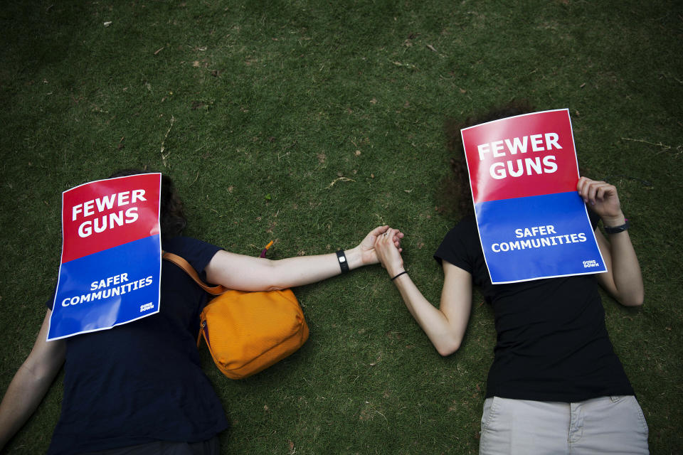 FILE - In this April 28, 2017, file photo, demonstrators hold hands during a "die-in" protest against the National Rifle Association's annual convention where President Trump is scheduled to speak a few blocks away in Atlanta. The National Rifle Association is gathering for its 148th annual meeting beginning Thursday, April 25, 2019, in Indianapolis. (AP Photo/David Goldman, File)