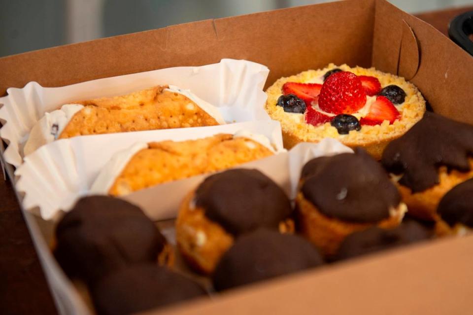 A tart, eclairs and cannolis are packed for a customer at Harvest Bay Artisan Bakery in Bay St. Louis on Thursday, Dec. 7, 2023.