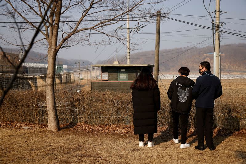 FOTO DE ARCHIVO. Un desertor norcoreano y sus hijos parados frente a una valla de alambre de púas cerca de la zona desmilitarizada que separa las dos Coreas, en Paju