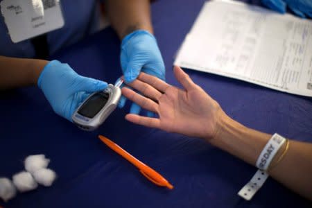 FILE PHOTO: A person receives a test for diabetes during Care Harbor LA free medical clinic in Los Angeles, California September 11, 2014. REUTERS/Mario Anzuoni/File Photo