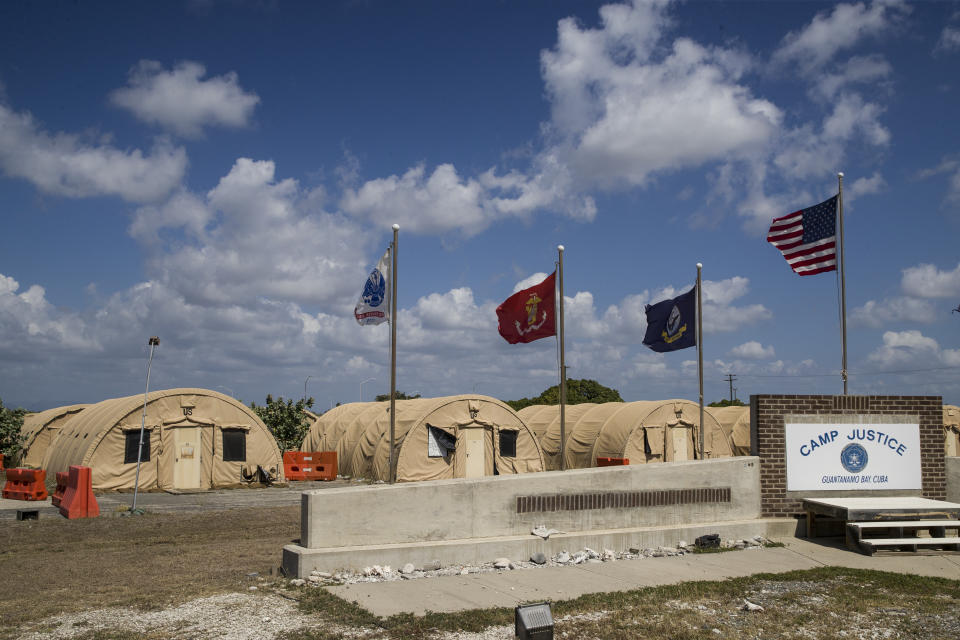 FILE - In this April 18, 2019, file photo, in this photo reviewed by U.S. military officials, flags fly in front of the tents of Camp Justice in Guantanamo Bay Naval Base, Cuba. A plan to offer the COVID-19 vaccine to prisoners at the Guantanamo Bay detention center, which was halted earlier in 2021 amid a political backlash, is on again as health authorities on April 19, 2021 expanded the vaccination program on the Navy base in Cuba to the entire adult population of the remote facility (AP Photo/Alex Brandon, File)