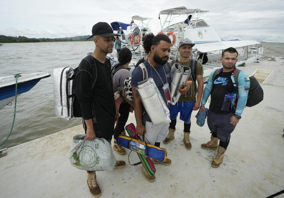 Venezuelan migrant Cristian Casamayor, second from left, arrives to Necocli, Colombia with fellow Venezuelan migrants after they decided against crossing the Darien Gap and returned from Acandi, Thursday, Oct. 13, 2022. Some Venezuelans are reconsidering their journey to the U.S. after the U.S. announced on Oct. 12 that Venezuelans who walk or swim across the border will be immediately returned to Mexico without rights to seek asylum. (AP Photo/Fernando Vergara)