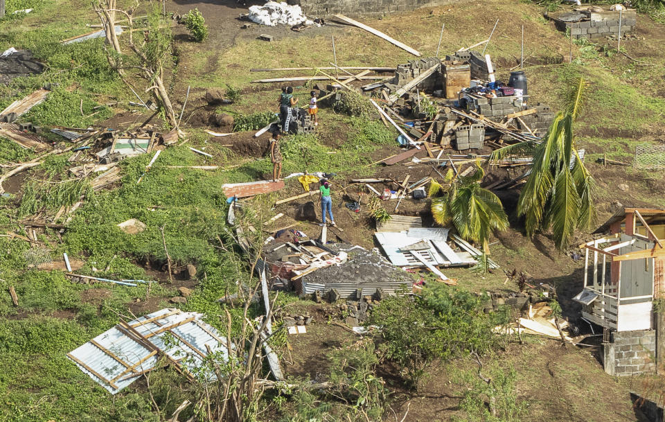 Familiares revisan su vivienda destrozada por el paso del huracán Beryl, en Ottley Hall, en San Vicente y las Granadinas, el martes 2 de julio de 2024. (AP Foto/Lucanus Ollivierre)