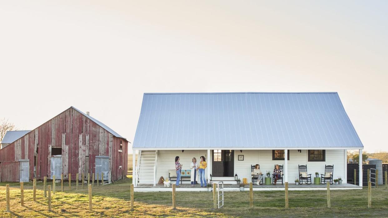 small white farmhouse and red barn