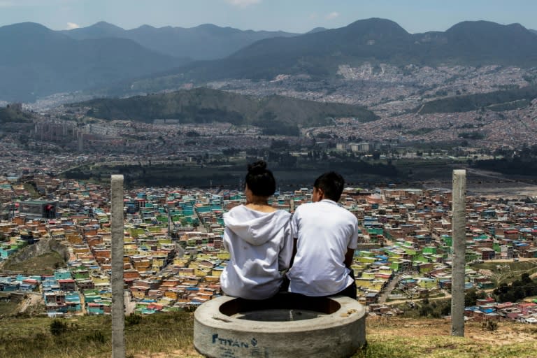Turistas observan el barrio Ciudad Bolívar, uno de los más pobres de Bogotá, durante un recorrido por la capital colombiana, el 14 de abril de 2024 (Alejandro MARTINEZ)