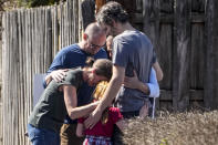 A group prays with a child outside the reunification center at the Woodmont Baptist church after a school shooting, Monday, March 27, 2023, in Nashville, Tenn. (AP Photo/John Bazemore)