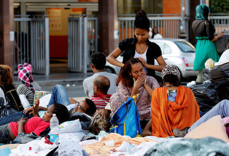 Refugees are seen on a street after being forcibly removed from a building where they had been living, in central Rome, Italy, August 20, 2017. REUTERS/Alessandro Bianchi