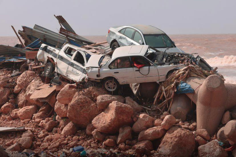 Several cars and a lot of metal debris piled up on a beach after flooding caused by Storm Daniel in Derna, Libya.