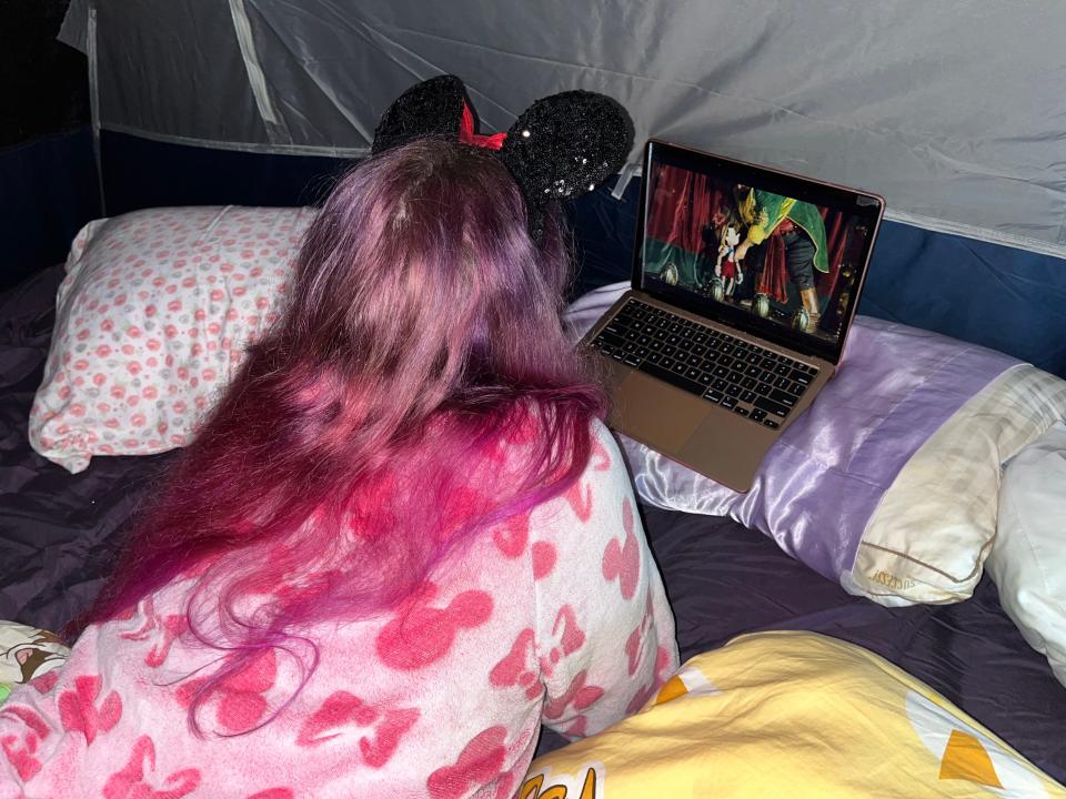 the writer watching pinnochio on laptop in tent