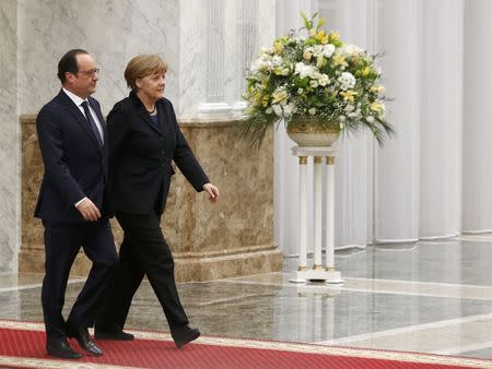 Germany's Chancellor Angela Merkel (R) and France's President Francois Hollande walk before a meeting with Belarus' President Alexander Lukashenko in Minsk, February 11, 2015. REUTERS/Vasily Fedosenko