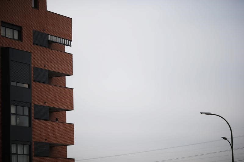 En la imagen de archivo, una mujer asomada a un balcón de un bloque de pisos en venta en Madrid, el 7 de diciembre de 2012. REUTERS/Susana Vera