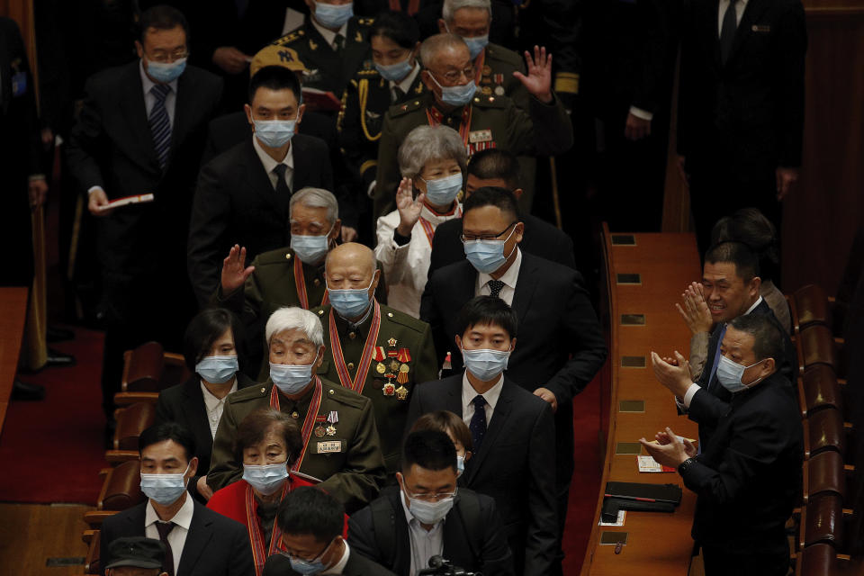 Delegates wearing face masks to help curb the spread of the coronavirus applaud as masked veteran soldiers arrive to attend the commemorating conference on the 70th anniversary of China’s entry into the 1950-53 Korean War, at the Great Hall fo the People in Beijing, Friday, Oct. 23, 2020. (AP Photo/Andy Wong)