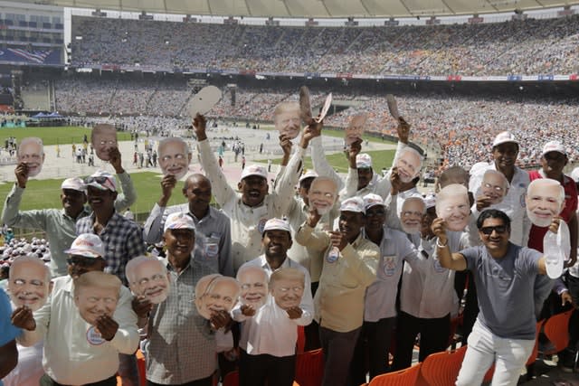 Indians hold masks of US President Donald Trump and Prime Minister Narendra Modi at Sardar Patel Stadium in Ahmedabad