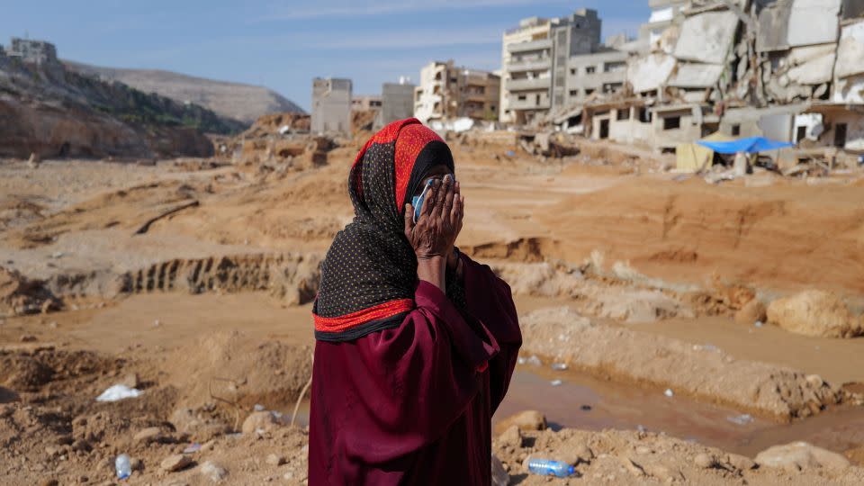 Aisha, 51, who said she lost five family members when the deadly storm hit her city, reacts as she walks past destroyed houses, in Derna, Libya on Sunday. - Zohra Bensemra/Reuters