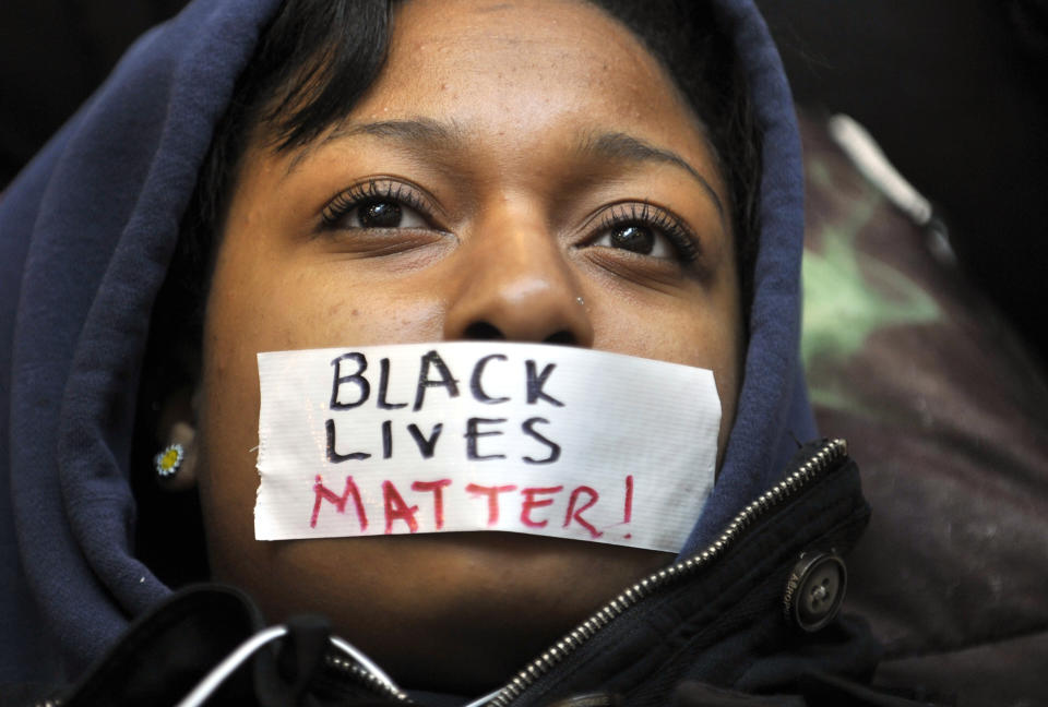 FILE - In this Dec. 2, 2014, file photo, Penn State student Zaniya Joe wears a piece of tape over her mouth that says Black Lives Matter, as a group of Penn State University students protest in University Park, Pa., following events in Ferguson, Mo. Nationally, the phrase Black Lives Matter was praised for its clarity and attacked as strident and offensive to police. But support grew as the list of slain black people got longer: Michael Brown, Eric Garner, Walter Scott, Alton Sterling, Philando Castile. (Nabil K. Mark/Centre Daily Times via AP, File)