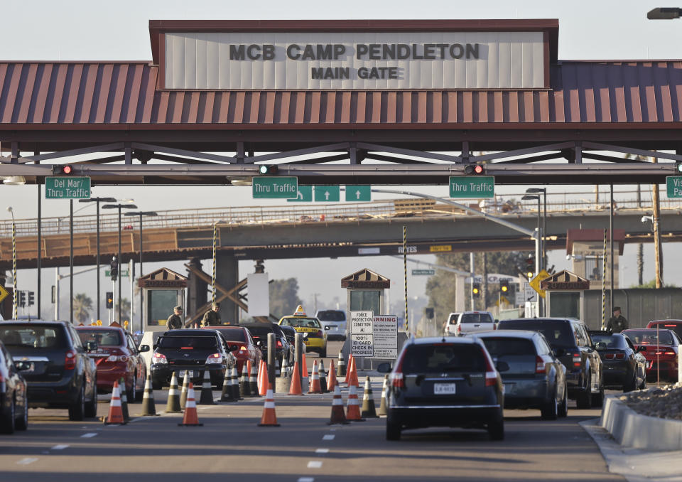 FILE - In this Nov. 13, 2013 file photo vehicles file through the main gate of Camp Pendleton Marine Base at Camp Pendleton, Calif. A human smuggling investigation by the military led to the arrest of 16 Marines Thursday, July 25, 2019 while carrying out a battalion formation at California's Camp Pendleton, a base about an hour's drive from the U.S.-Mexico border. (AP Photo/Lenny Ignelzi, File)