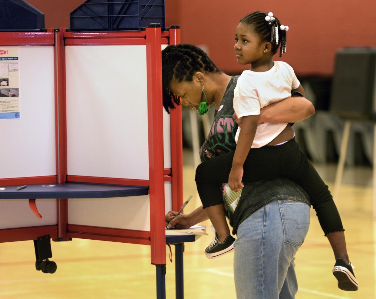 Melissa Booker holds her daughter, Addison Lathan, 3, as Booker votes at Union Baptist Church Tuesday, April 4, 2023, on election day.