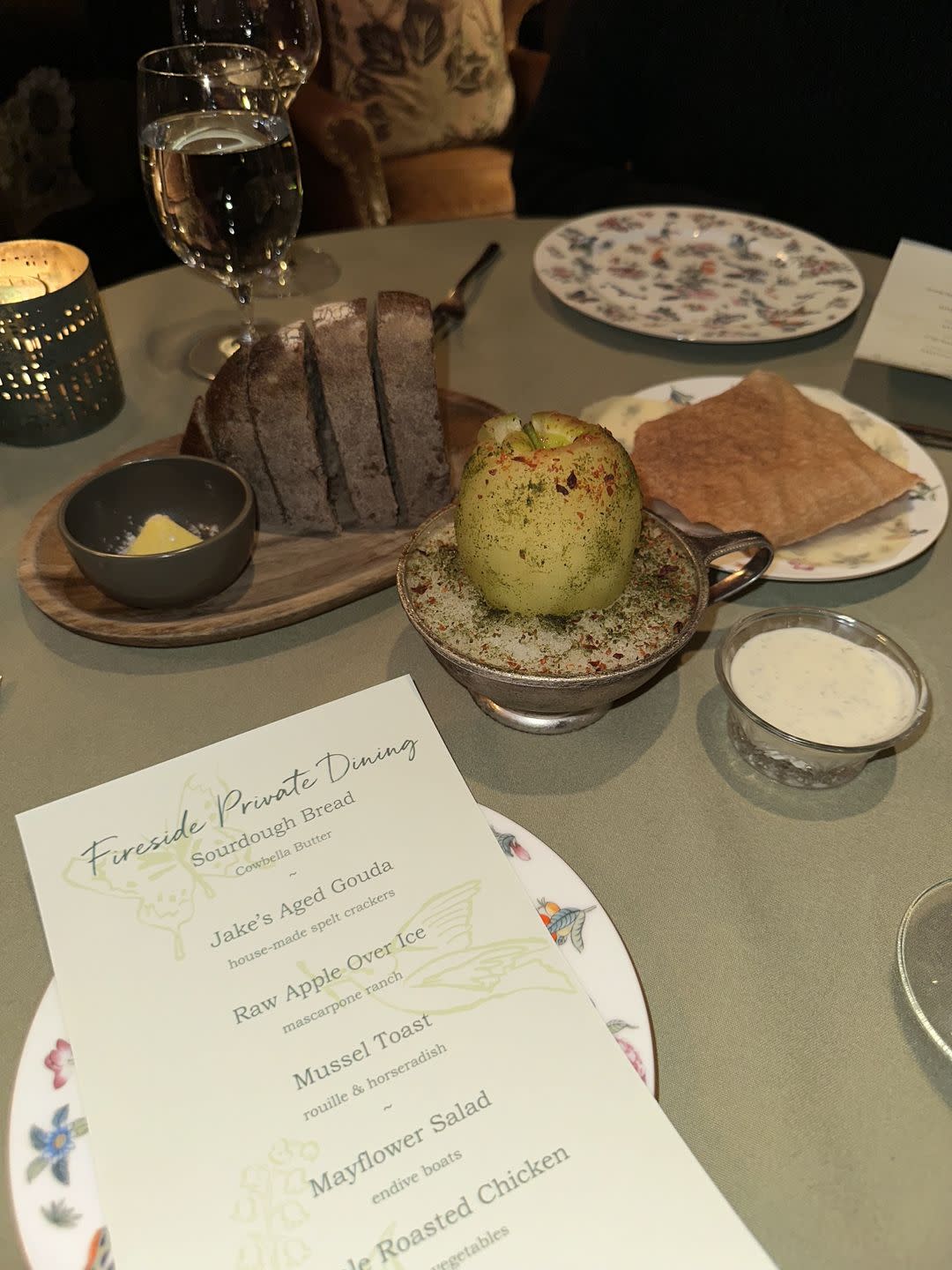 a table with plates of food and glasses of wine