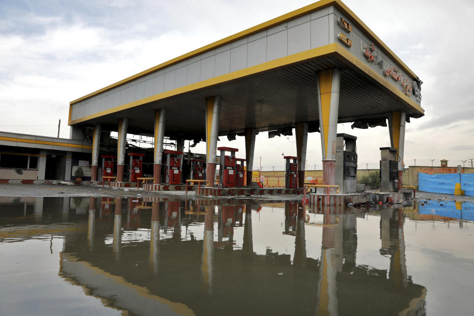 FILE - In this Nov. 20, 2019, file photo, a gas station that was attacked during protests over rises in government-set gasoline prices is reflected in a puddle, in Tehran, Iran. Internet connectivity is trickling back in Iran after the government shut down access to the rest of the world for more than four days in response to unrest apparently triggered by a gasoline price hike. (AP Photo/Ebrahim Noroozi, File)