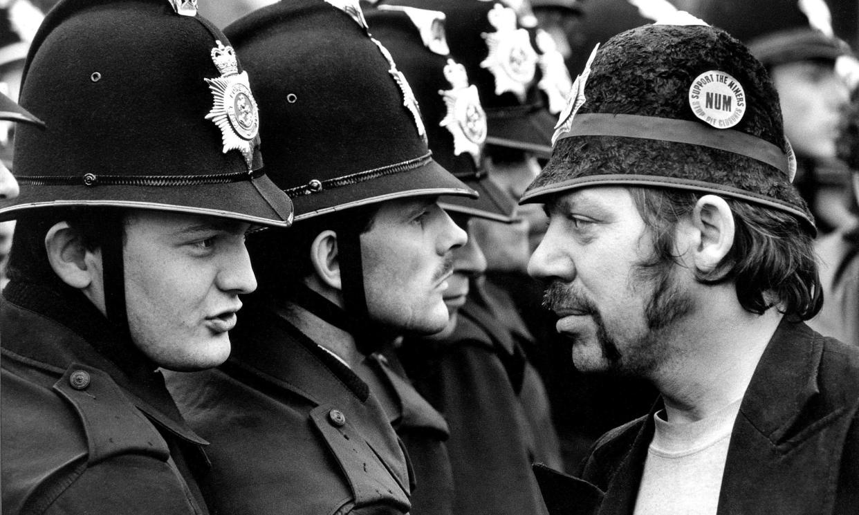 <span>A striking miner faces a line of police officers without identification numbers at the Orgreave coking plant, June 1984. </span><span>Photograph: Don McPhee/The Guardian</span>