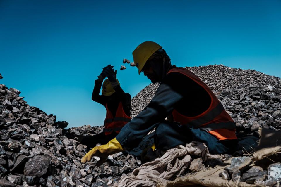 Workers sorting crushed rocks containing chromite