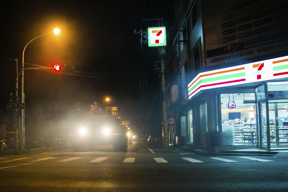 In this photo released by the Military News Agency, a tank rolls past a convenience store as it prepares to take part in the annual Han Kuang live-fire drills in Hualian, eastern Taiwan in the early hours of Tuesday, Sept. 14, 2021. (Military News Agency via AP)