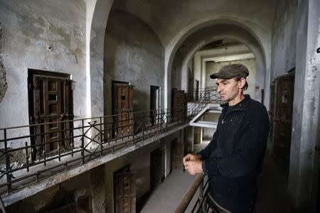 Nicu Vlasceanu, an unofficial tourist guide to the communist-era Ramnicu Sarat prison, looks on in the jail in eastern Romania September 23, 2014. REUTERS/Bogdan Cristel