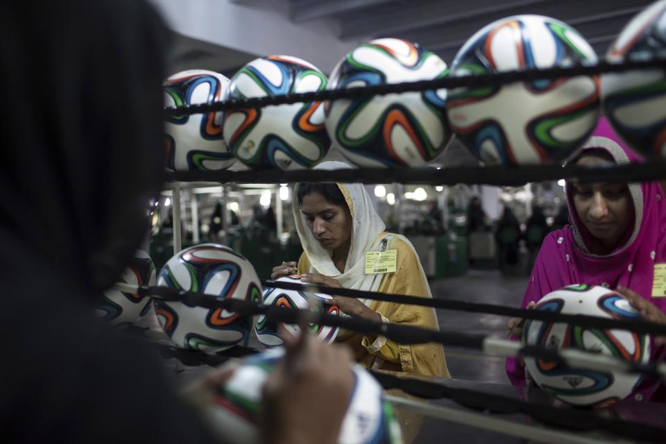 An employee conducts a final check on a ball inside the soccer ball factory that produces official match balls for the 2014 World Cup in Brazil, in Sialkot, Punjab province