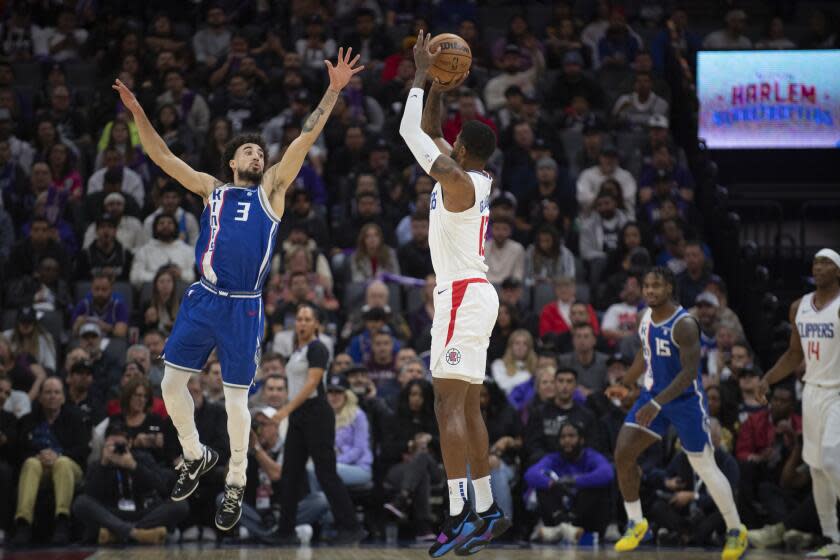 Los Angeles Clippers forward Paul George (13) shoots over Sacramento Kings guard Chris Duarte (3) in the first quarter of an NBA basketball game in Sacramento, Calif., Wednesday, Nov. 29, 2023. (AP Photo/José Luis Villegas)