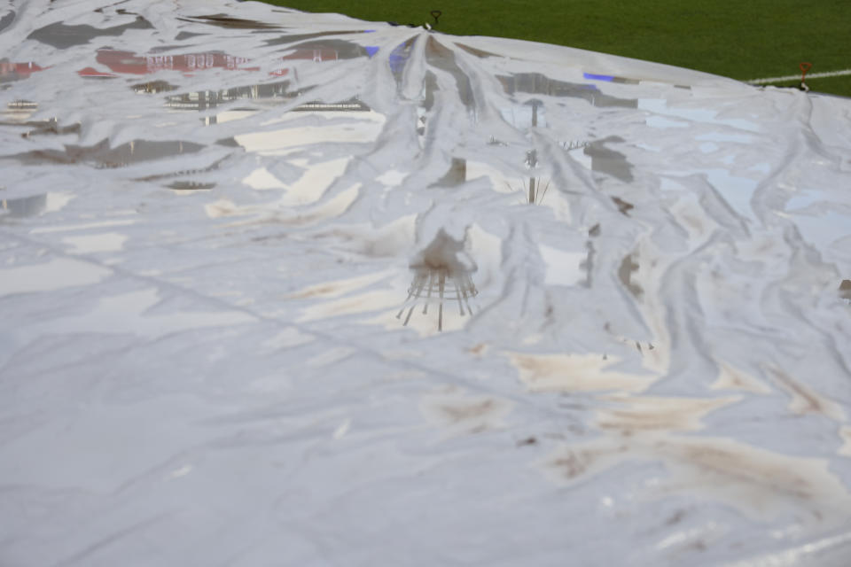 A reflection of the PNC Power Stacks are seen in the tarp covering the field prior to a baseball game between the Arizona Diamondbacks and the Cincinnati Reds in Cincinnati, Wednesday, June 8, 2022. The game has been delayed due to inclement weather. (AP Photo/Aaron Doster)