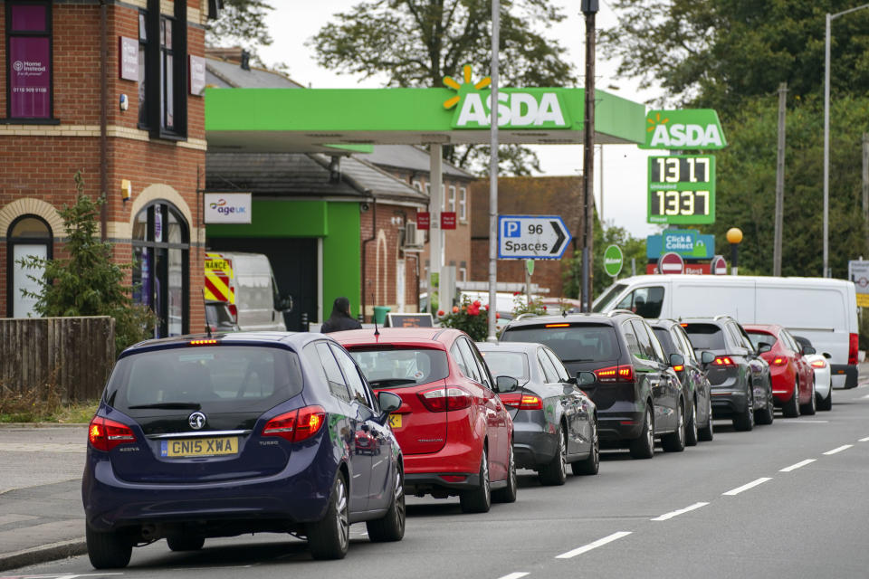 Cars queue outside a petrol station in Reading, England, Saturday Sept. 25, 2021. The haulage industry says the U.K. is short tens of thousands of truckers, due to a perfect storm of factors including the coronavirus pandemic, an aging workforce and an exodus of European Union workers following Britain’s departure from the bloc. BP and Esso shut a handful of their gas stations this week, and motorists have formed long lines as they try to fill up in case of further disruption. Steve Parsons/PA via AP)