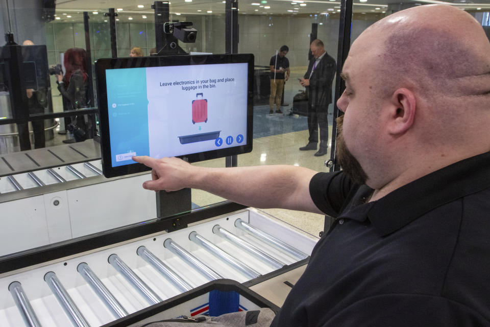 A TSA official demonstrates new screening equipment at Harry Reid International Airport, Wednesday, March 6, 2024, in Las Vegas. (AP Photo/Ty ONeil)