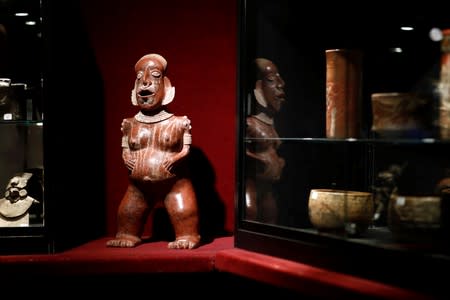 A statue of a pregnant woman standing up, one of pre-Columbian artefacts, is presented to the press at Drouot auction house in Paris