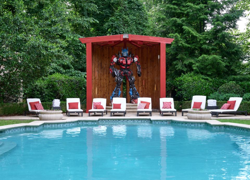 Modena lounge chairs facing the pool front a giant shed housing a custom Optimus Prime sculpture. Until Voltron Studios Hollywood is built, the Transformer will be safe from the elements beside Gibson’s pool.