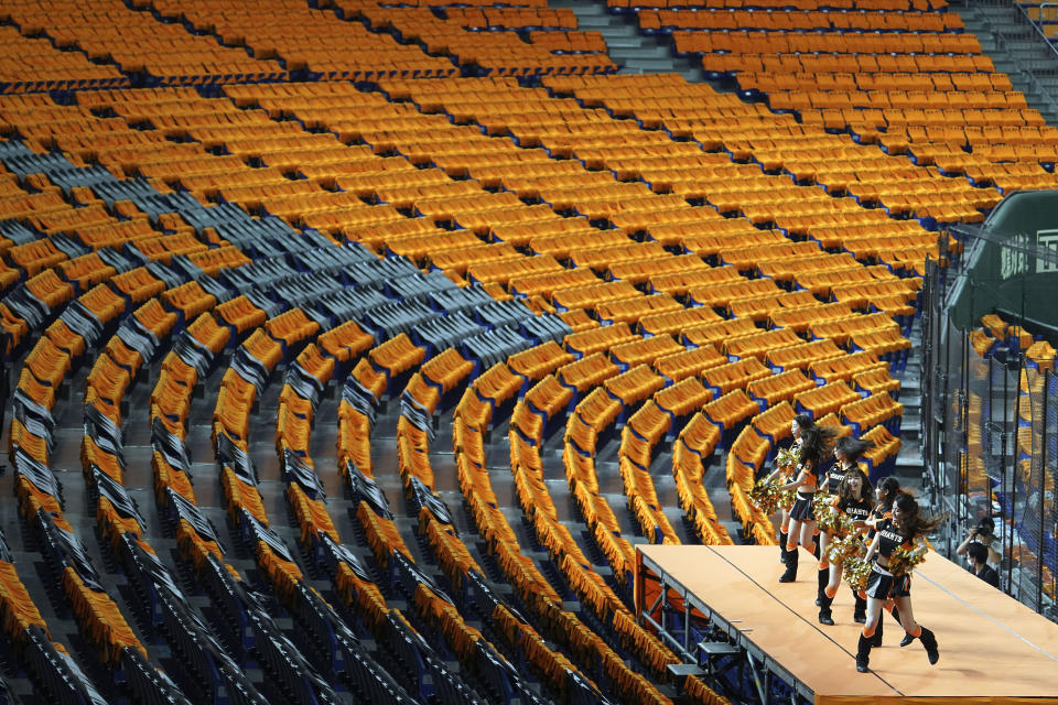 Cheer leaders perform to empty stands prior an opening baseball game between the Yomiuri Giants and the Hanshin Tigers at Tokyo Dome in Tokyo Friday, June 19, 2020. Japan’s economy is opening cautiously, with social-distancing restrictions amid the coronavirus pandemic. (AP Photo/Eugene Hoshiko)