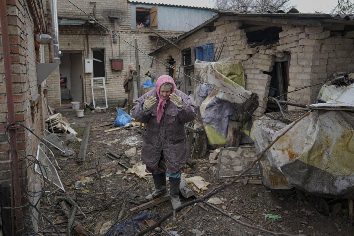 A woman is overwhelmed by emotion in the backyard of a house damaged by a Russian airstrike, according to locals, in Gorenka, outside the capital Kyiv, Ukraine, Wednesday, March 2, 2022.