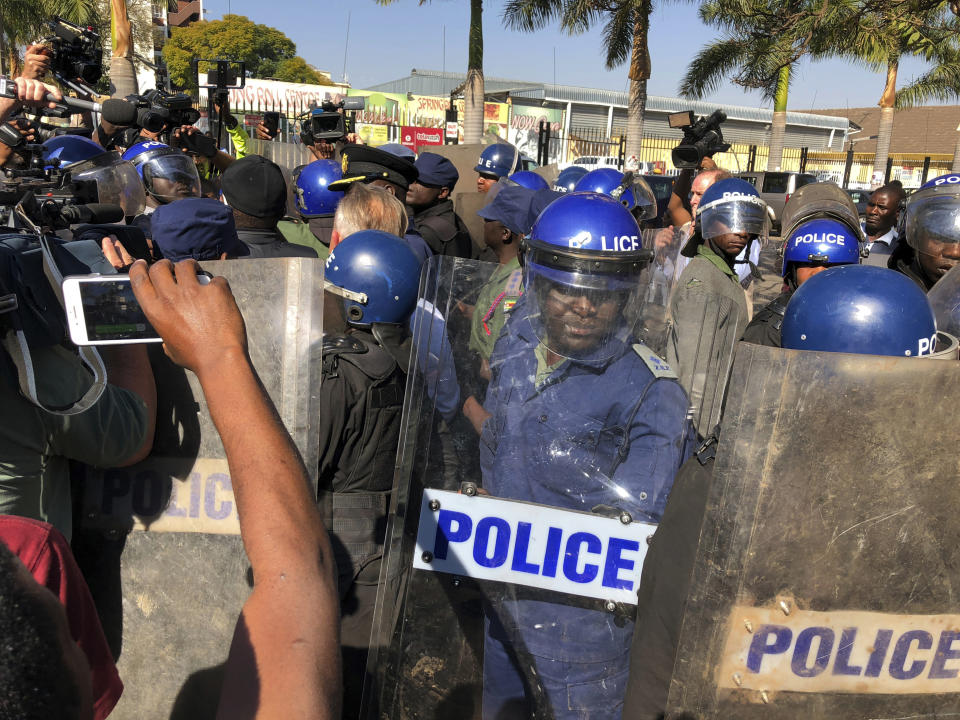 Riot police break up a press conference by opposition leader Nelson Chamisa in Harare, Zimbabwe, Friday Aug. 3, 2018. Hours after President Emmerson Mnangagwa was declared the winner of a tight election, riot police disrupted the press conference where opposition leader Nelson Chamisa was about to respond to the election results. (AP Photo/Jerome Delay)