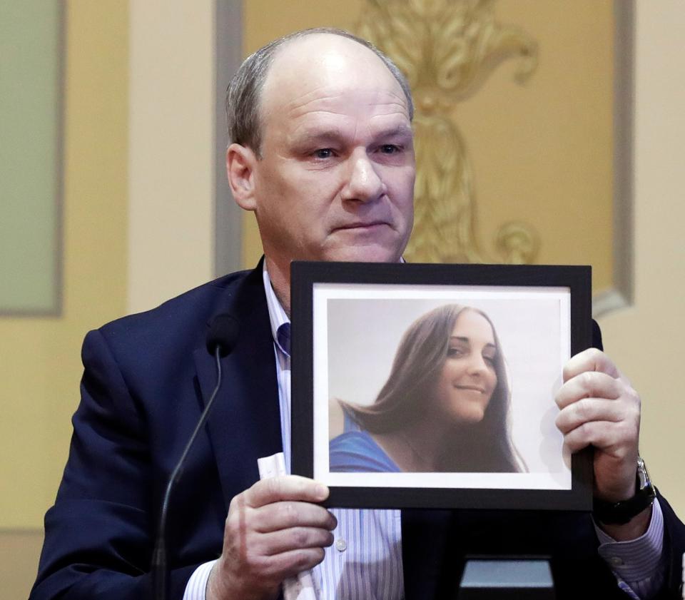 Steven Holstead holds a photo of his sister, Lisa, and looks directly at Lou Griffin during a sentencing hearing on March 27, 2023, in Green Bay, Wis. Griffin was sentenced to 10 years in prison for homicide by reckless conduct for killing Lisa Holstead in 1986.