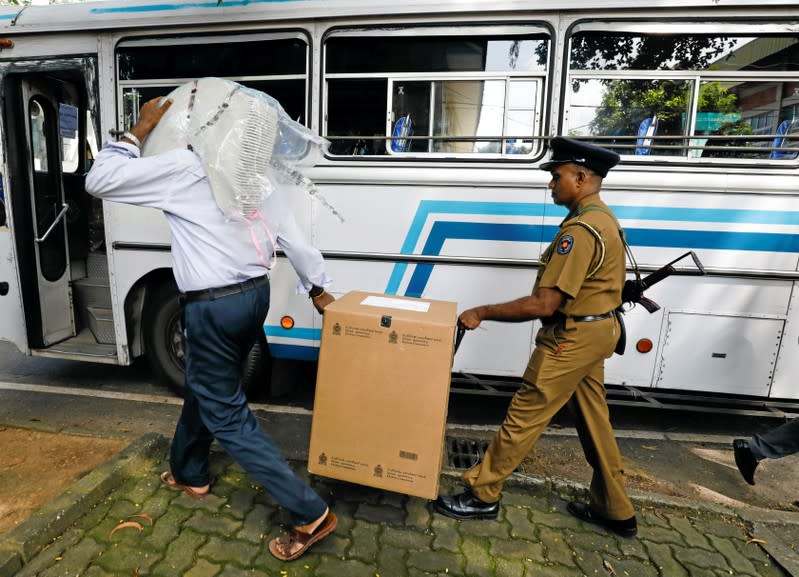 Sri Lankan police and election officials load ballot boxes and papers into busses from a distribution center to polling stations, ahead of country's presidential election scheduled on November 16, in Colombo
