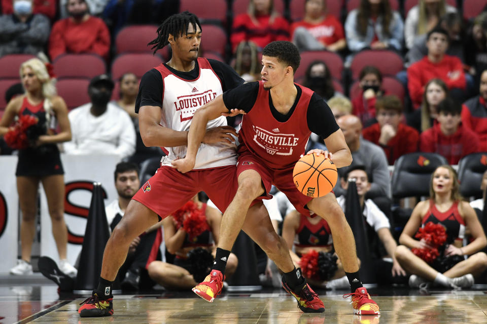 Louisville forward Samuell Williamson, right, attempts to work his way through the defense of guard Dre Davis (14) during an NCAA college basketball intersquad scrimmage in Louisville, Ky., Saturday, Oct. 16, 2021. (AP Photo/Timothy D. Easley)