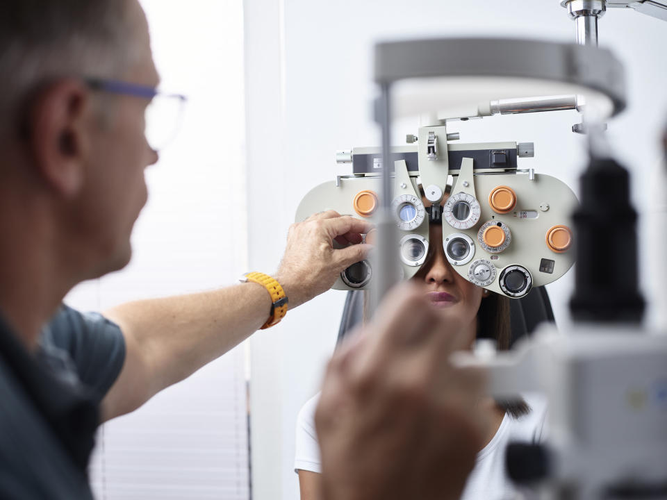 Optometrist examining young woman's eyes