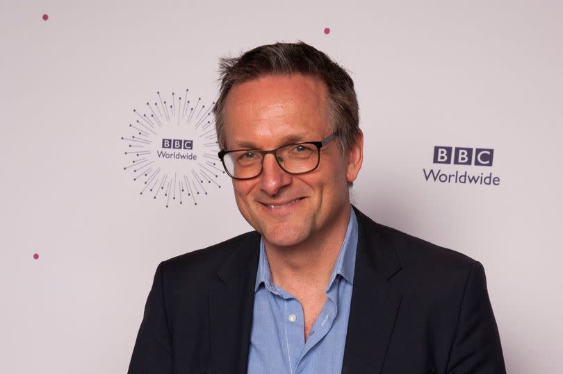 Michael Mosley posing in front of a white background with BBC Worldwide logos.