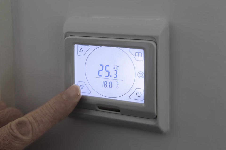 Person adjusting digital thermostat