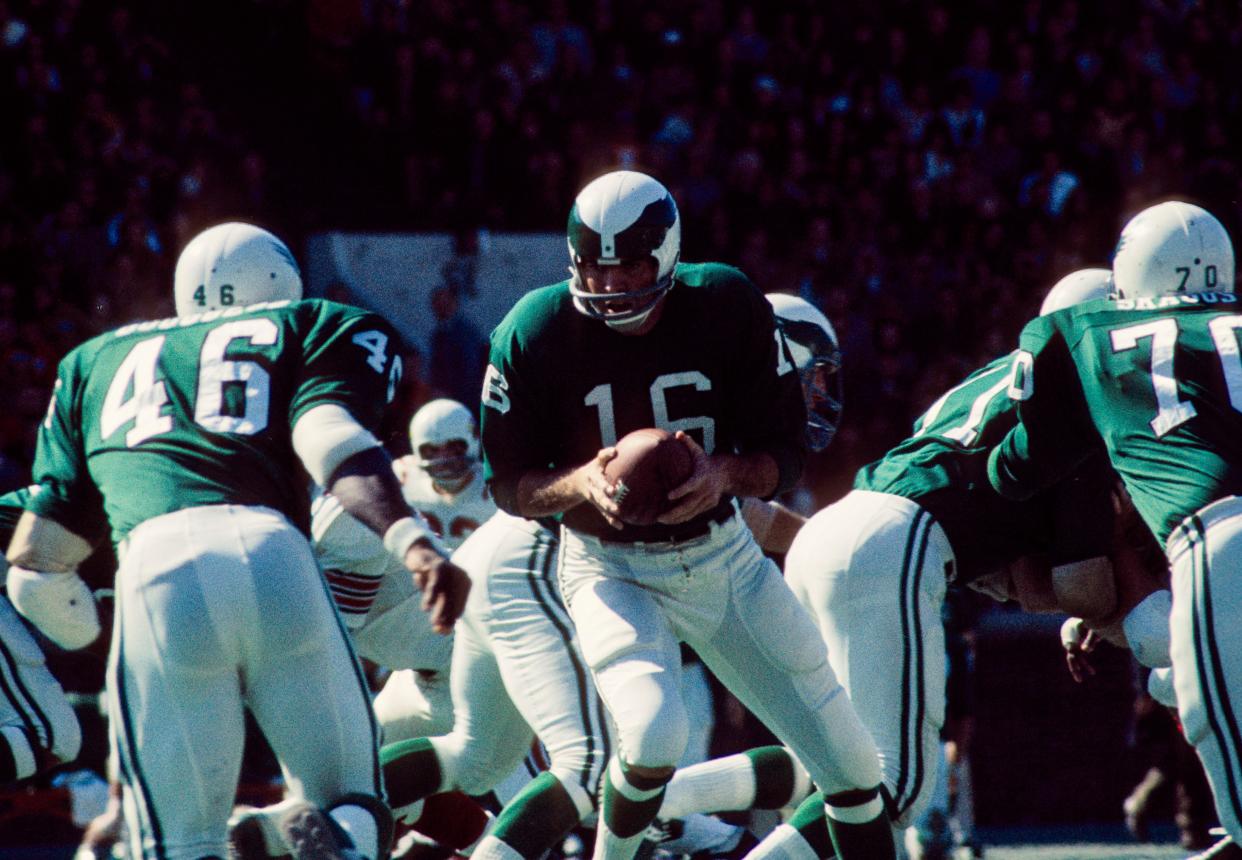 Philadelphia Eagles quarterback Norm Snead (turns to hand the ball off to running back Lee Bouggess at Franklin Field.