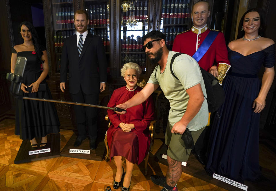 Un visitante se toma una selfie con una figura de cera de la reina Isabel II y otros miembros de la familia real el 8 de septiembre de 2022, en el museo de cera de la Ciudad de México. La monarca falleció el 8 de septiembre tras ocupar el trono durante 70 años. Tenía 96 años. (AP Foto/Fernando Llano)